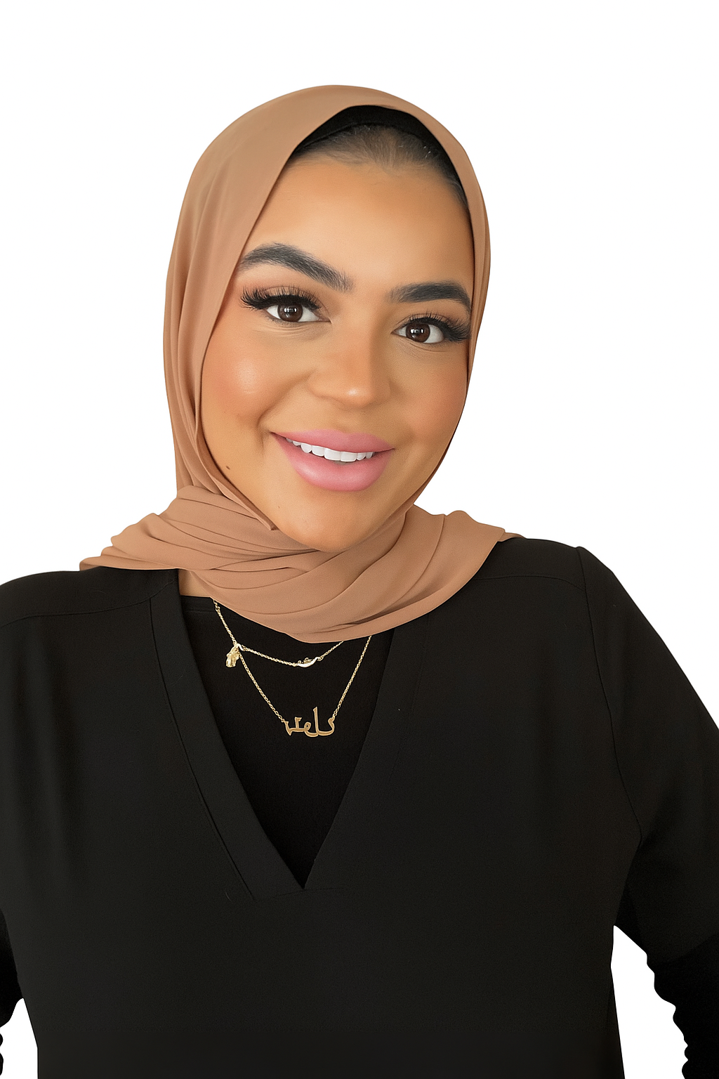 A woman wearing a hijab and a necklace is smiling for the camera.