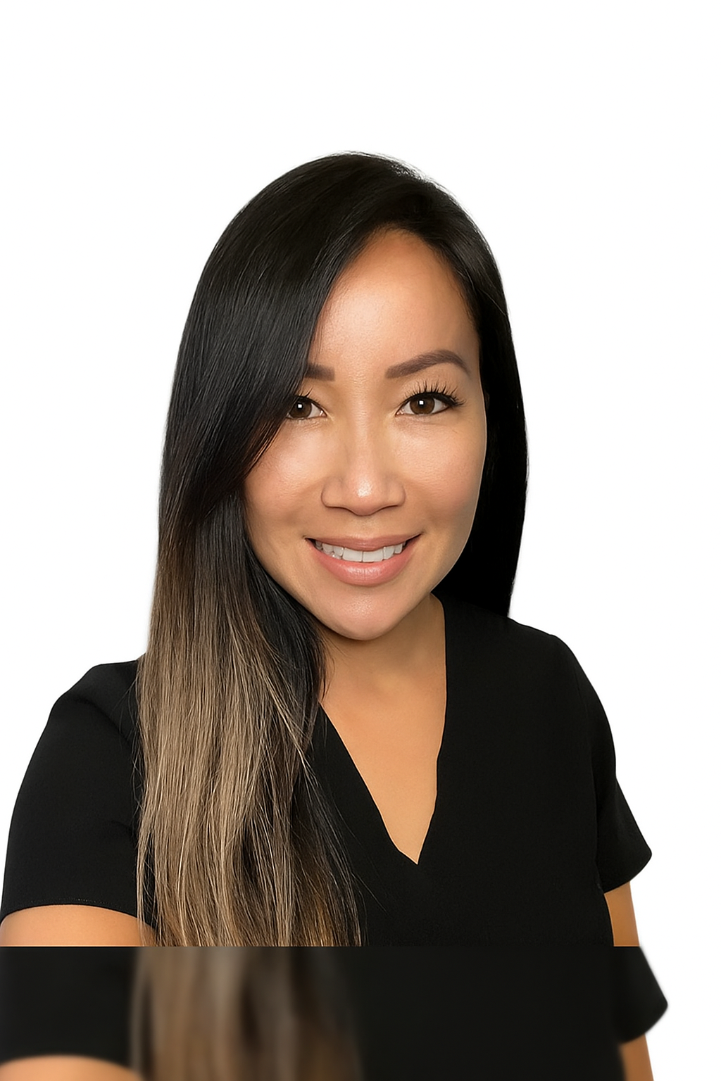 A woman in a black scrub top is smiling for the camera.