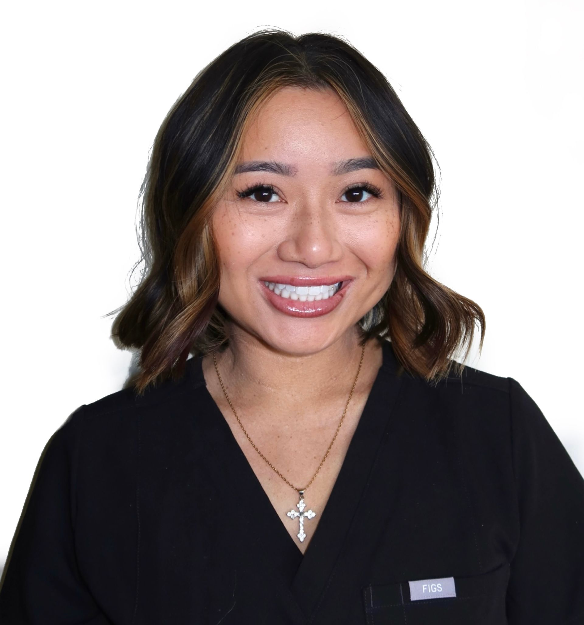 Smiling person in a black top with a silver necklace against a white background