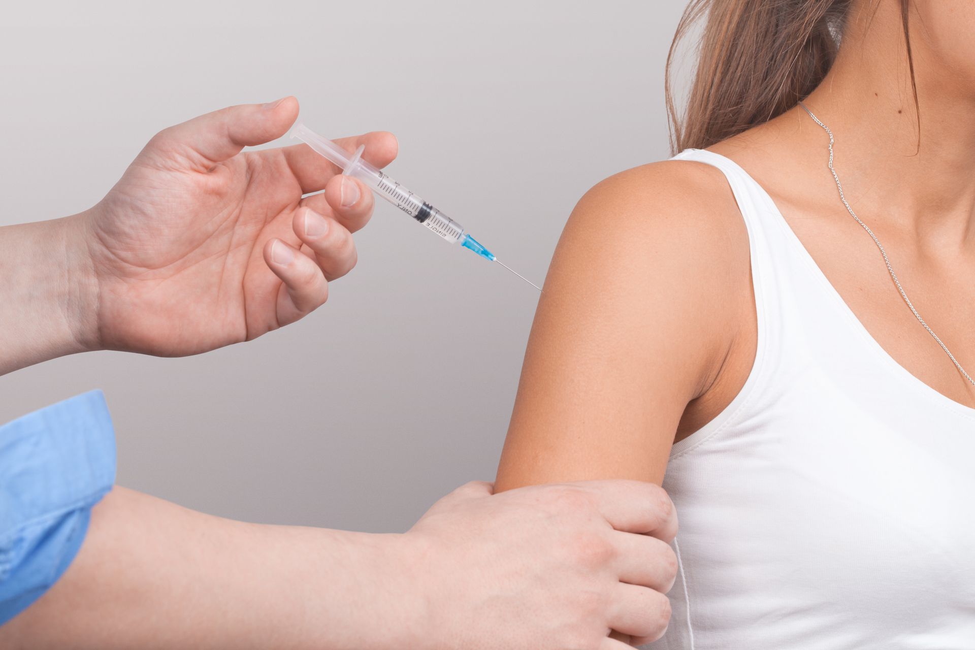 a woman is getting an injection in her arm