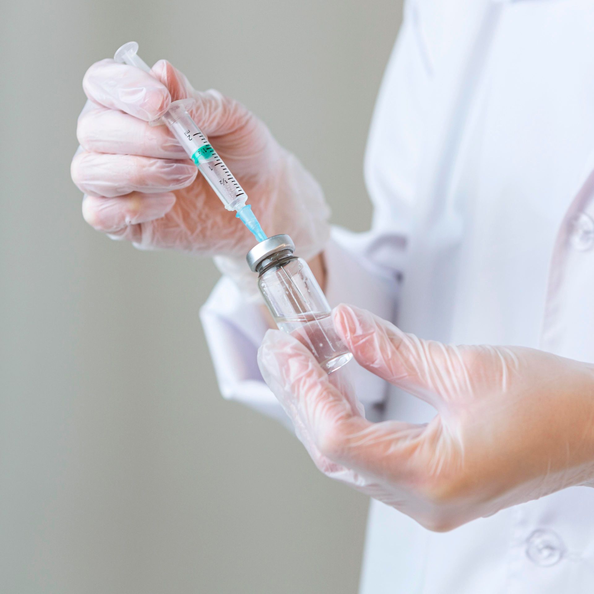 a person is holding a syringe and a bottle of liquid