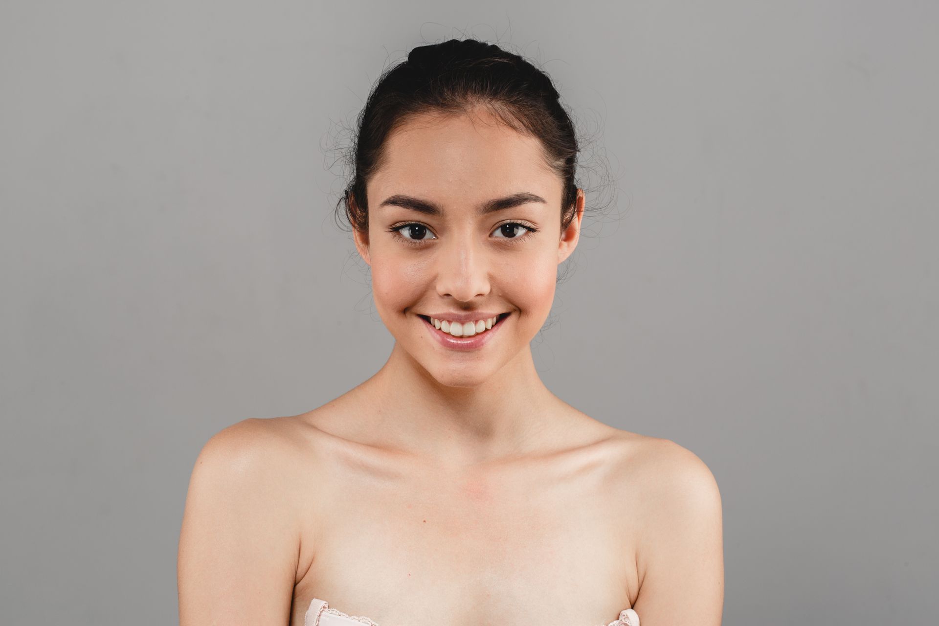 a woman without a shirt is smiling and looking at the camera