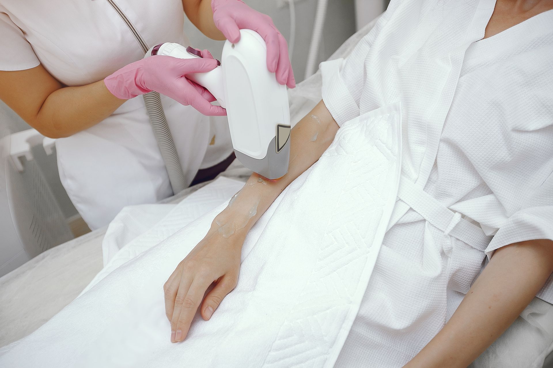 a woman is getting a hair removal treatment on her arm