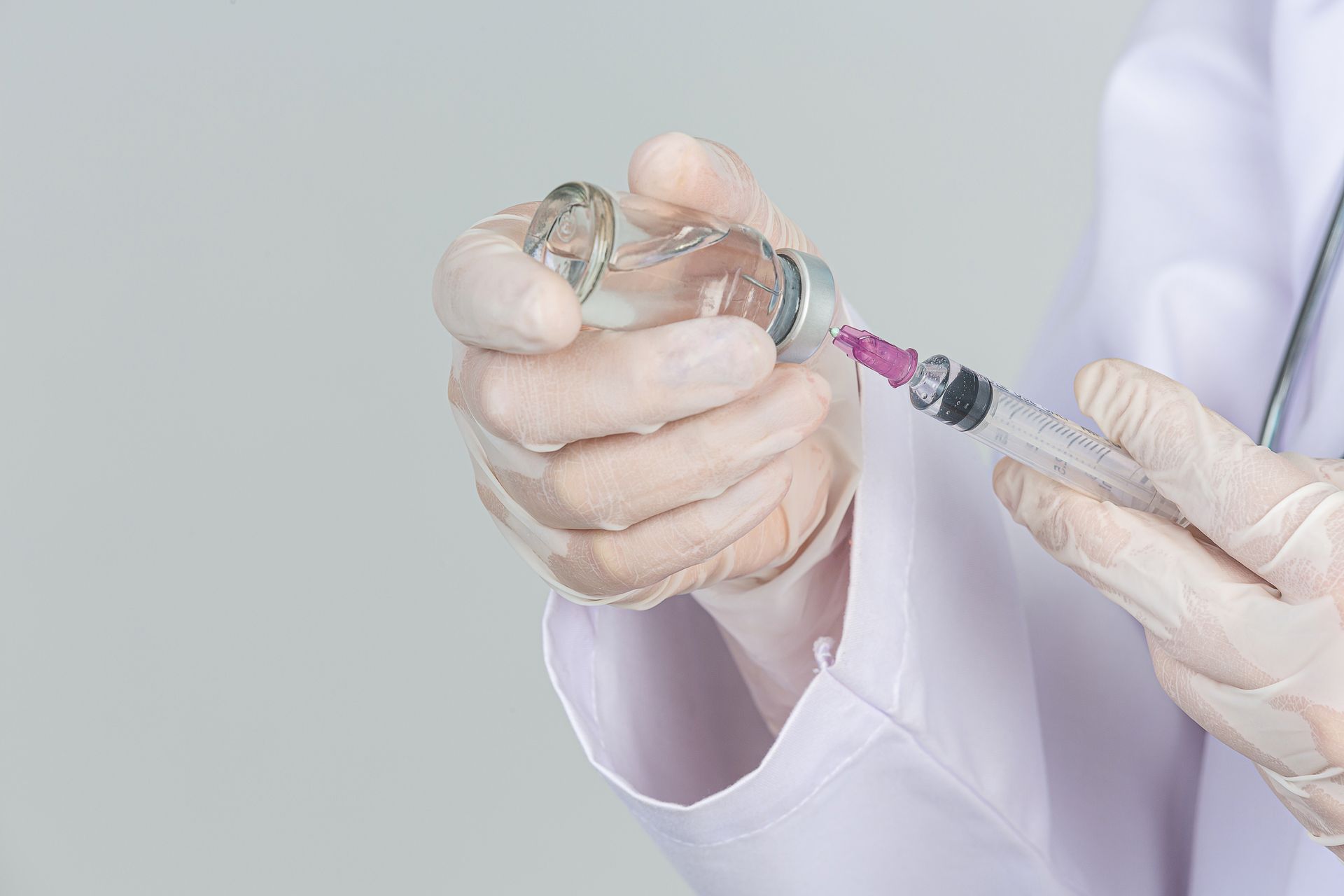 a doctor is holding a syringe and a bottle of liquid