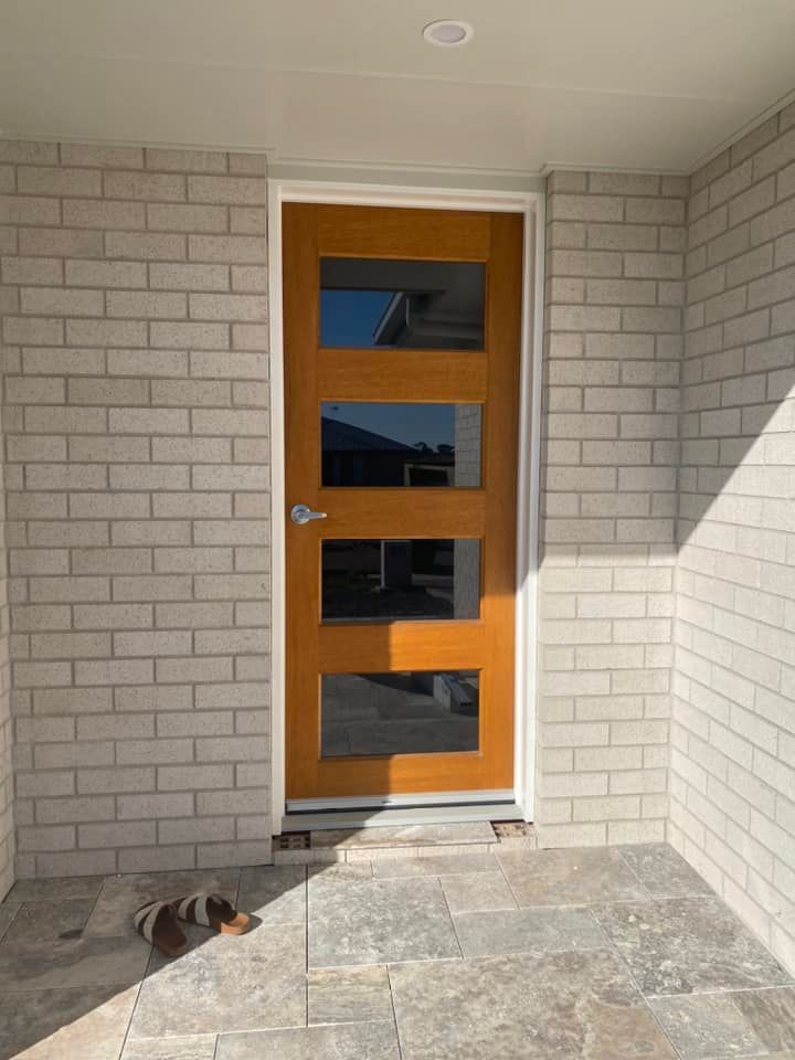 Brown Door With Glass Panels in a Brick-walled Entryway — Wide Bay Tinting in Bargara, QLD