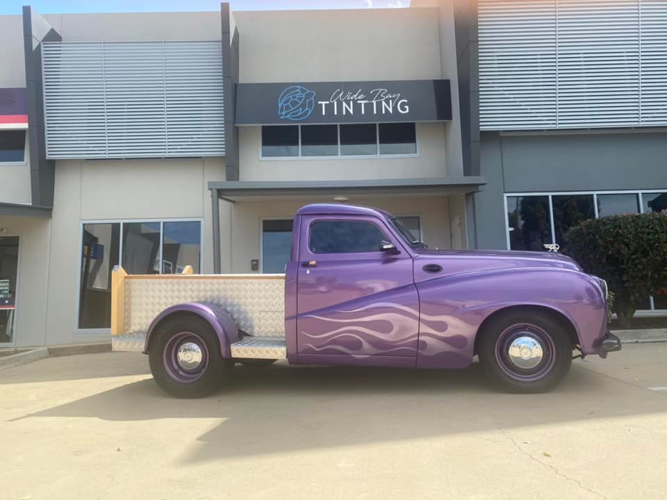 Purple vintage pickup truck with flame decals parked in front of a window tinting business — Wide Bay Tinting in Kensington, QLD