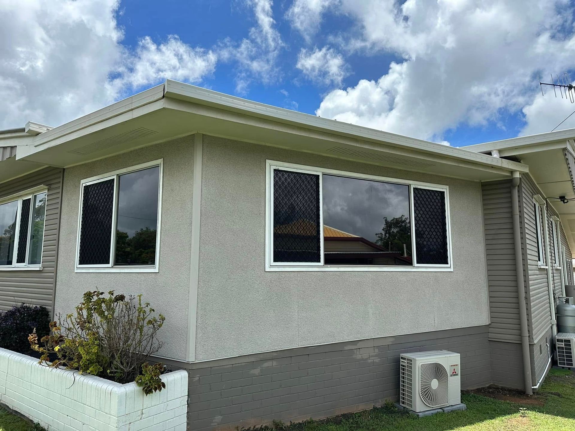 Exterior View of a Light-colored Building With Multiple Windows Covered by Screens — Wide Bay Tinting in Gin Gin, QLD