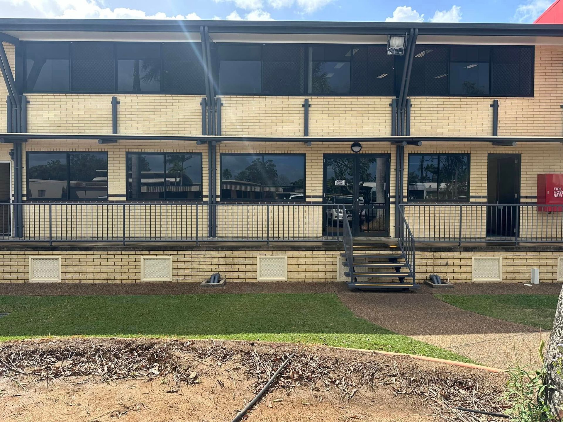 Two-Story Building With Tan Exterior, Black Windows — Wide Bay Tinting in Sharon, QLD