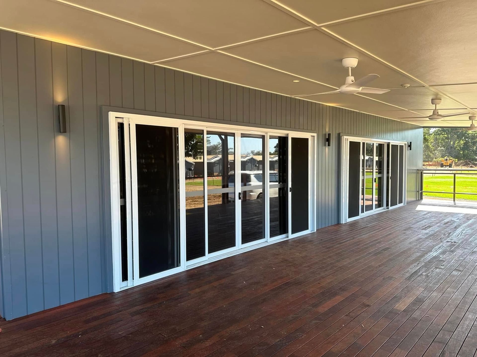 Covered Outdoor Space With Dark Wooden Deck — Wide Bay Tinting in Sharon, QLD