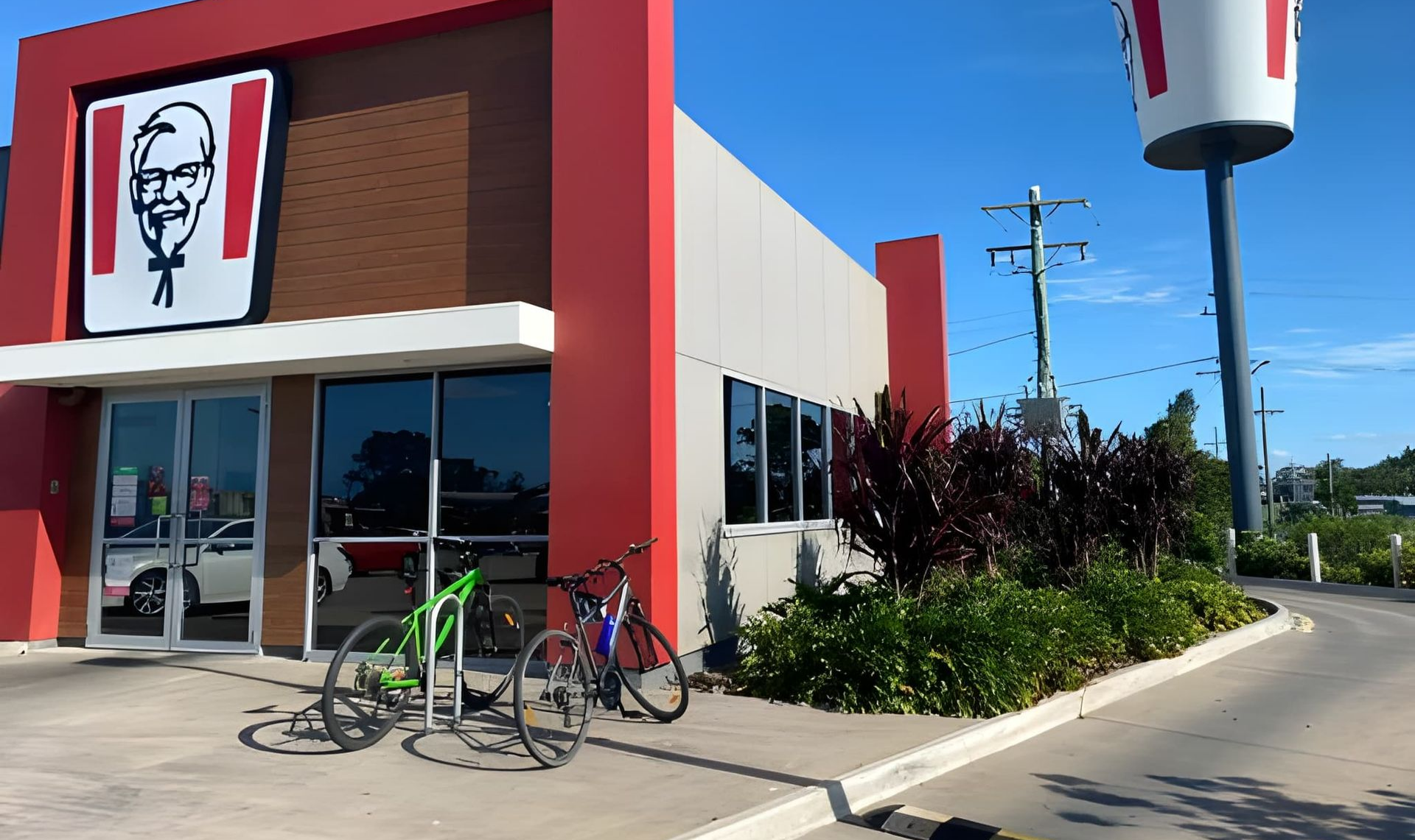 KFC Restaurant With Red and White Exterior, Bicycles Parked Out Front — Wide Bay Tinting in Kensington, QLD