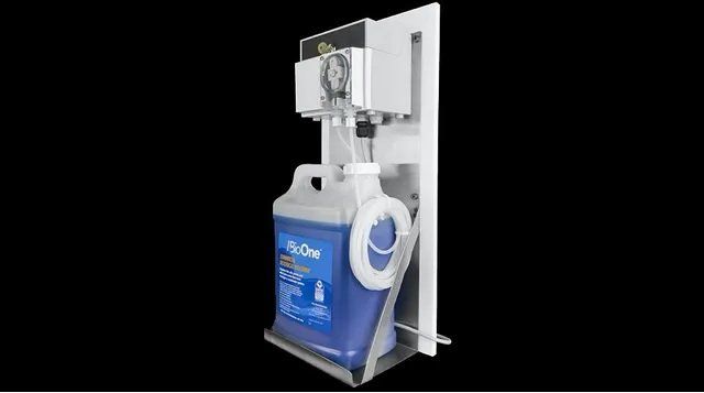 Dispenser system with a blue liquid container. White mounting plate, metal base, and a tube.