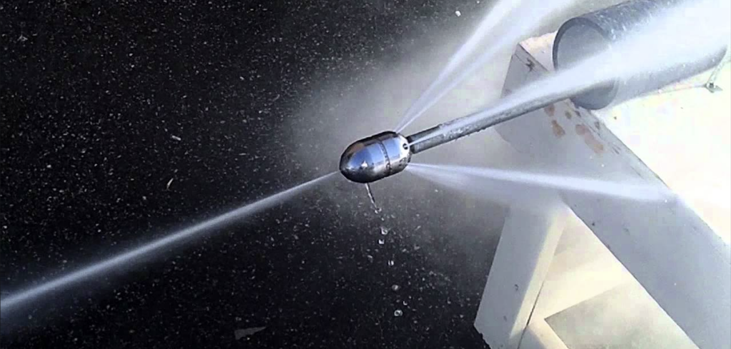 A high-pressure water jet spraying water towards a surface.