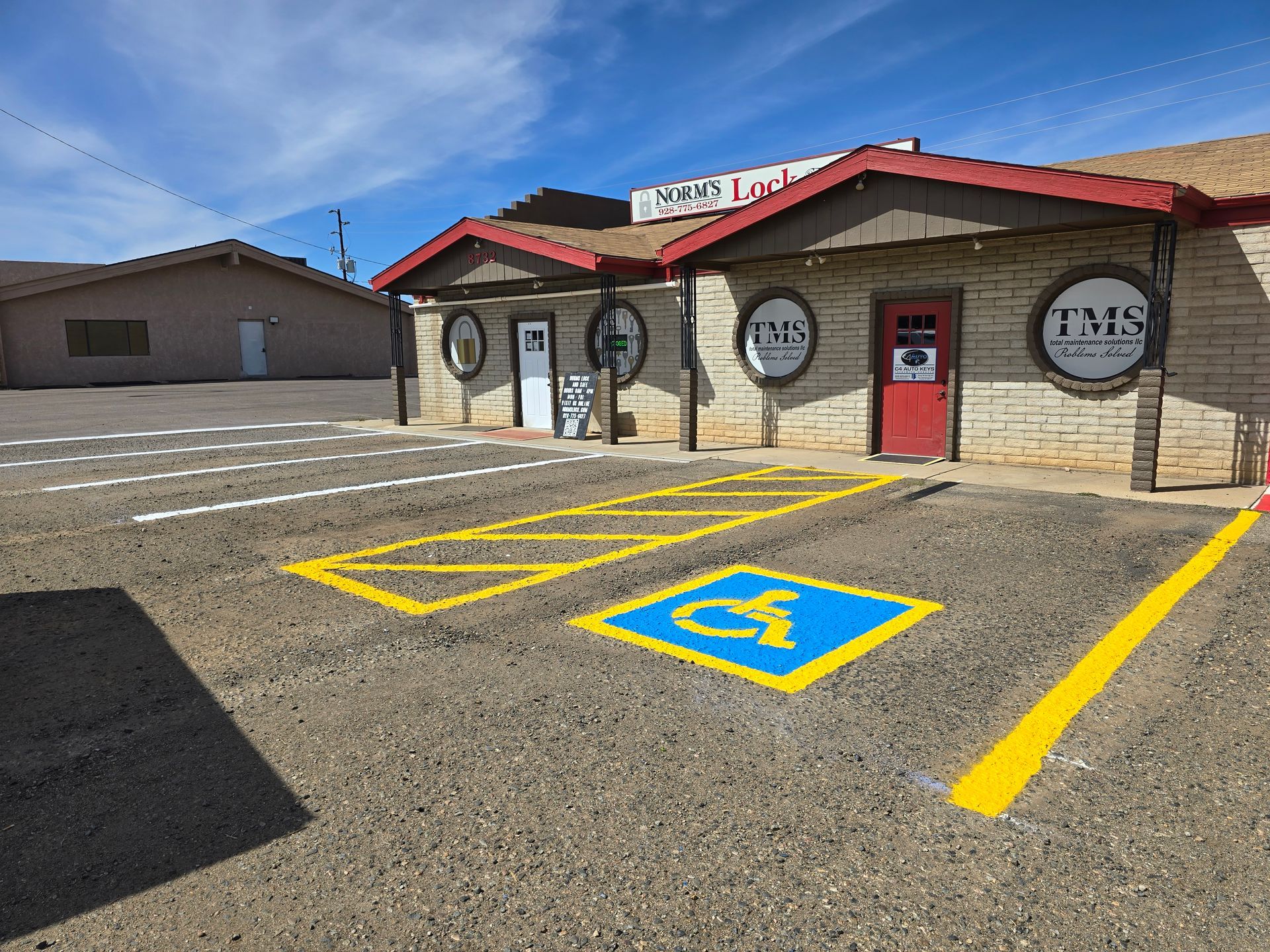 A worker in a yellow safety vest uses a power trowel to smooth wet concrete at a construction site with a pump truck.