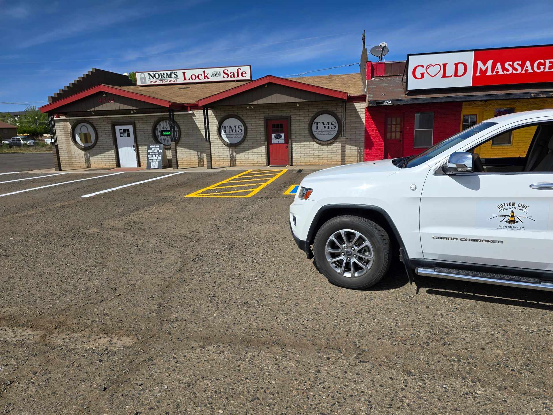 A white painted International Symbol of Access (wheelchair symbol) on a dark gray asphalt surface.