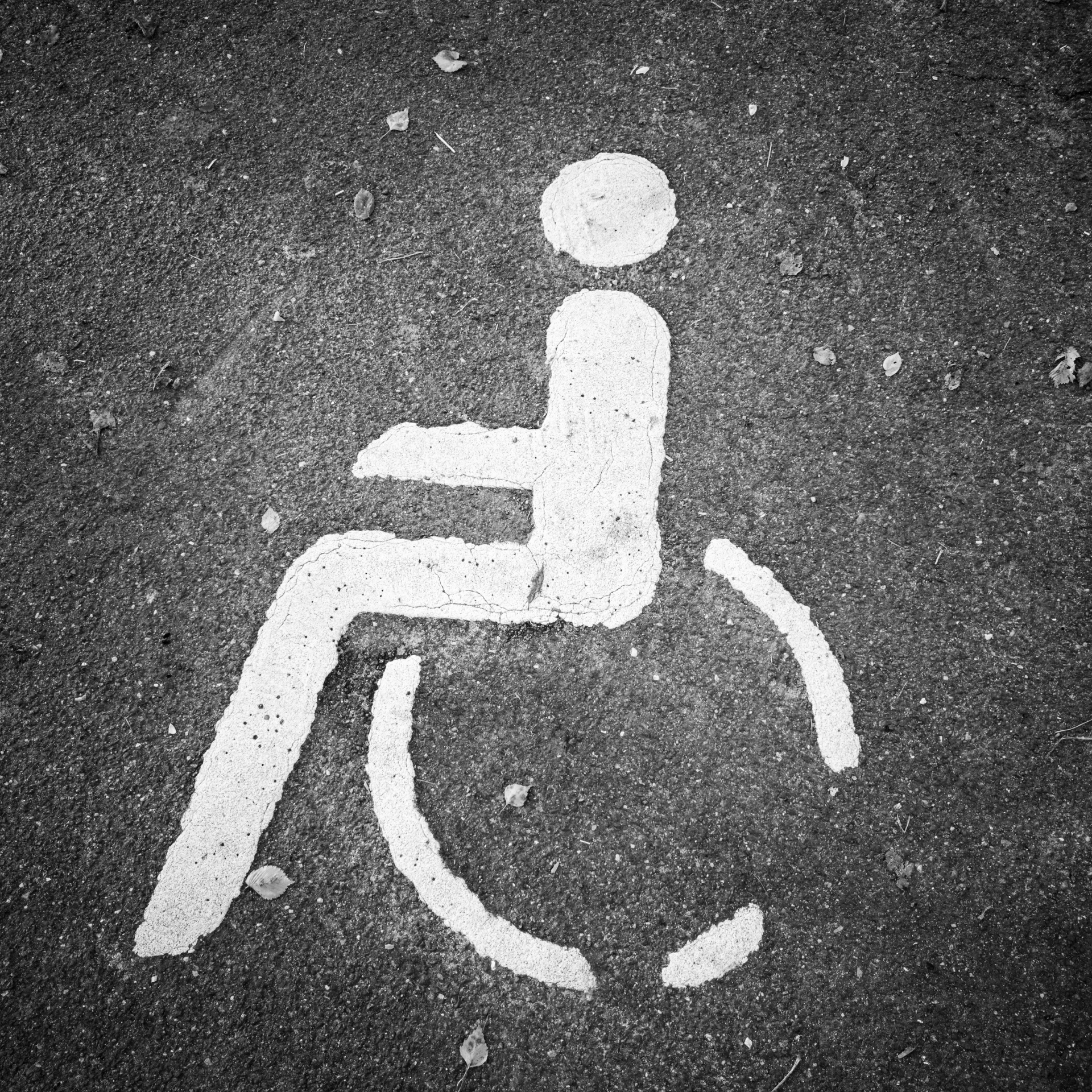 Three pieces of yellow road construction equipment paving a road against a clear blue sky.
