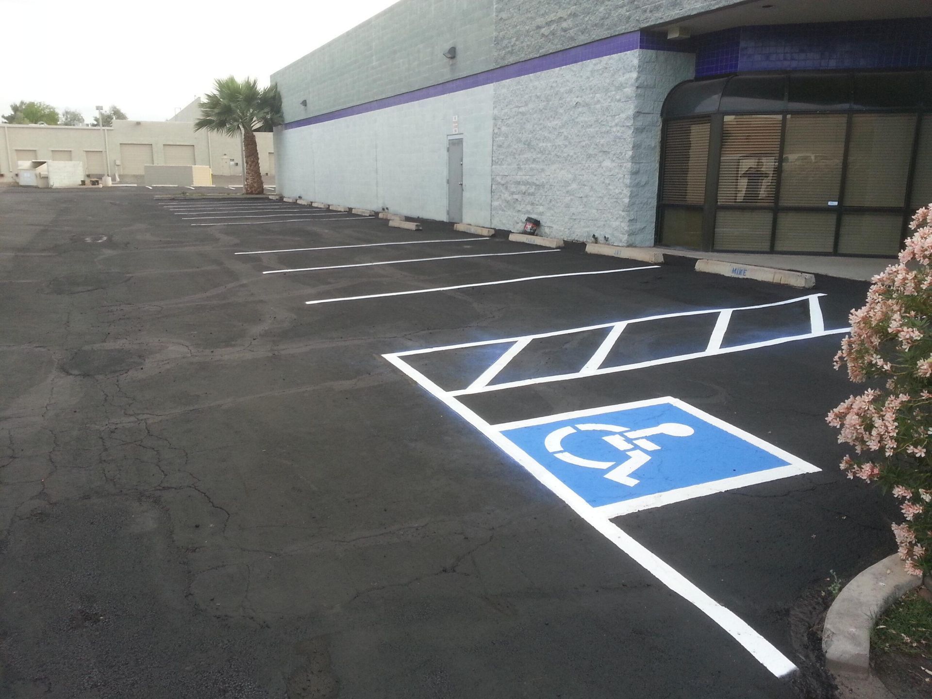 Construction workers in hard hats work on a road at sunset, with heavy equipment in the background.