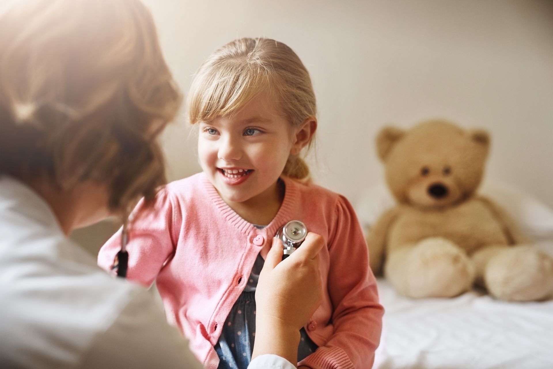 A little girl is being examined by a doctor with a stethoscope.