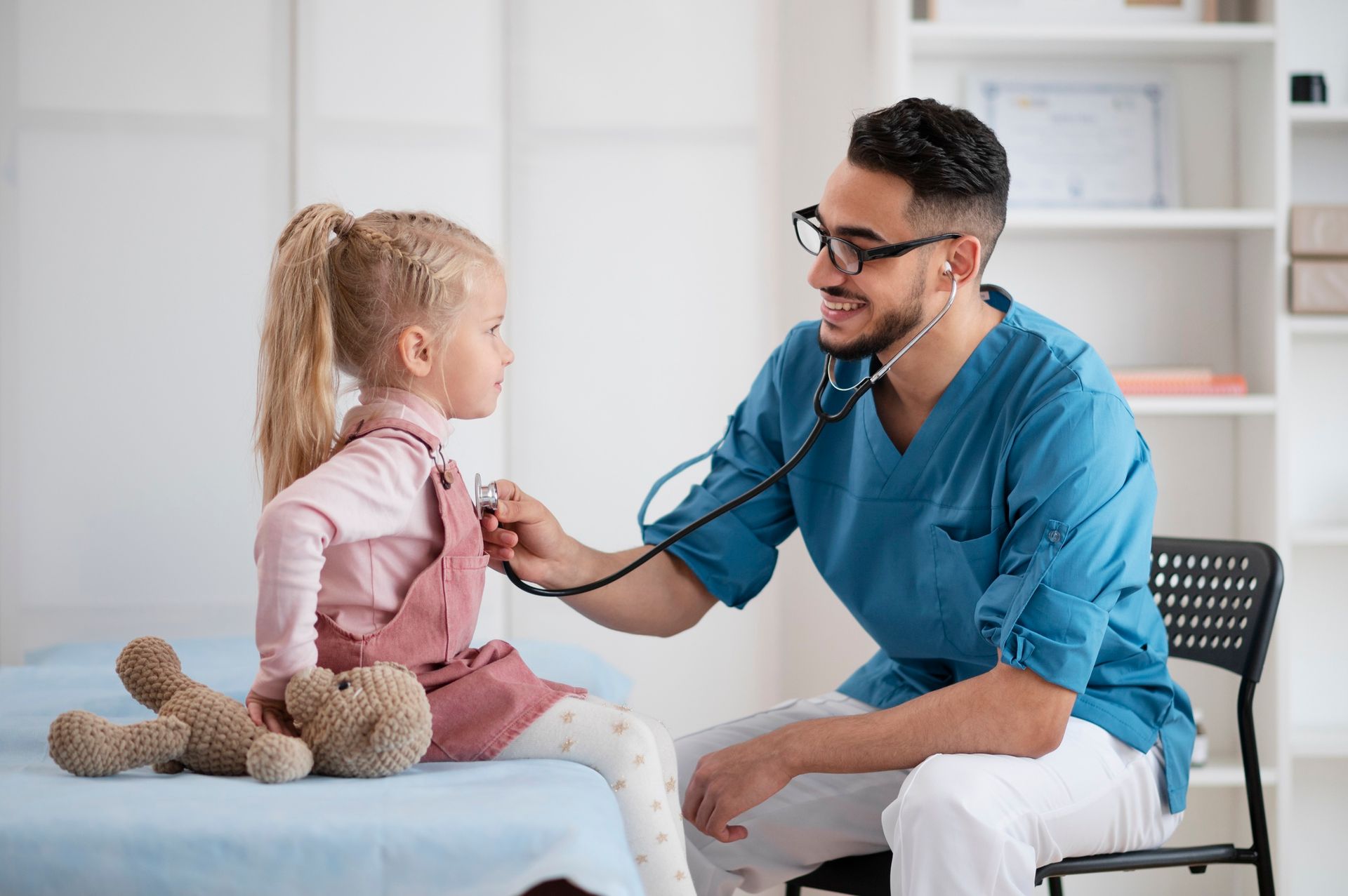 A doctor is listening to a little girl 's heart with a stethoscope.