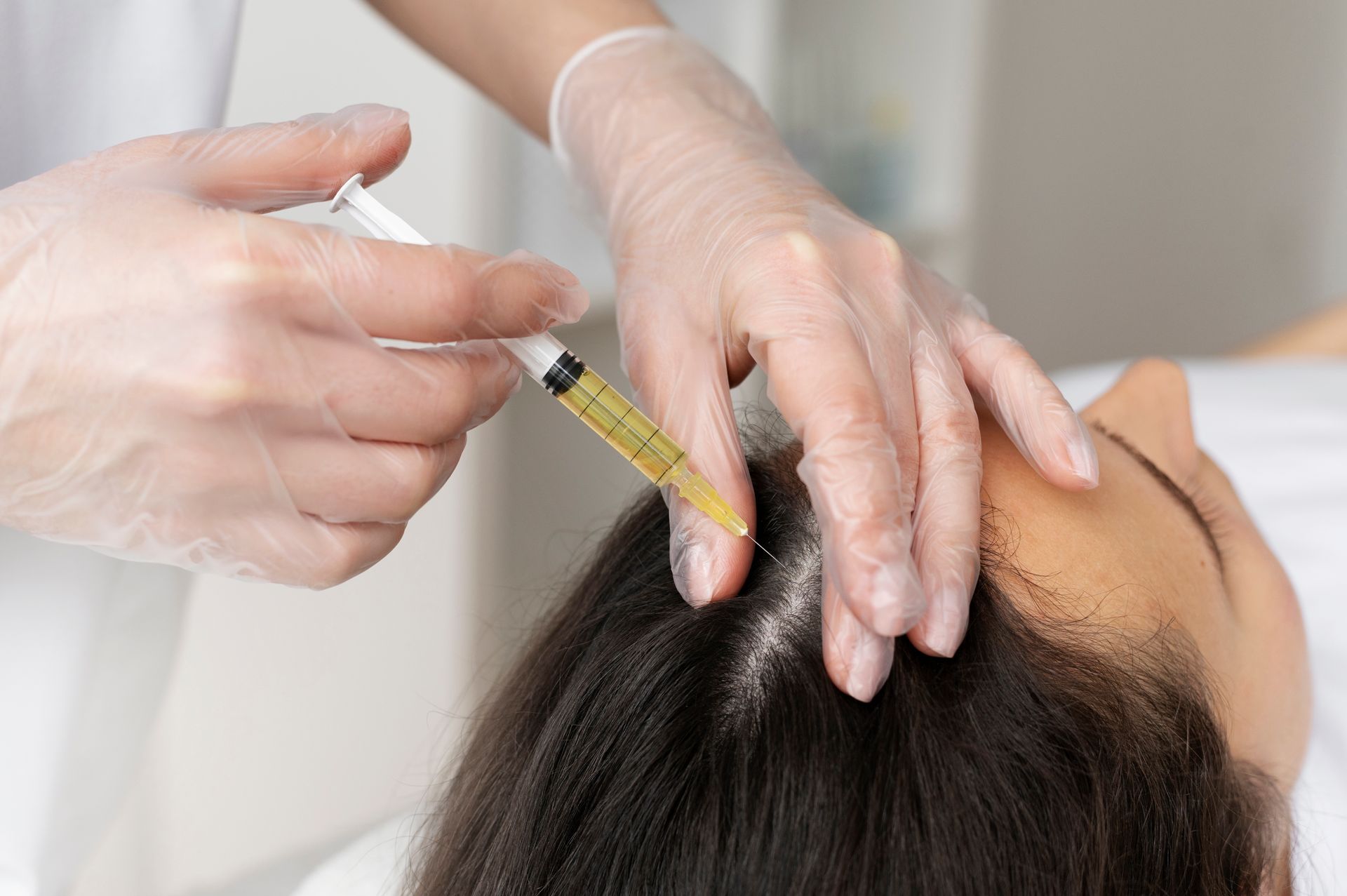 A woman is getting an injection in her hair.
