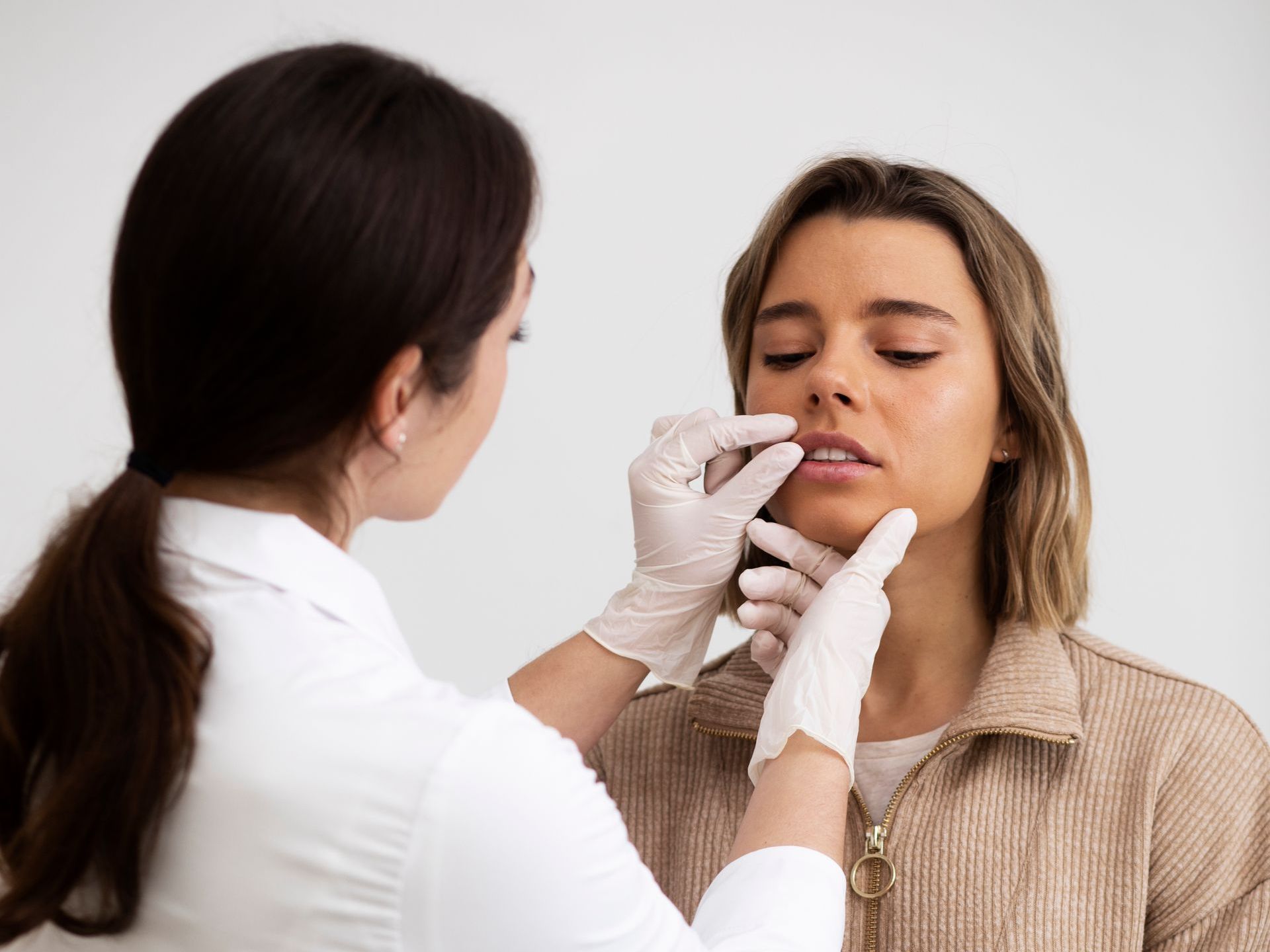 A woman is getting a botox injection in her forehead.