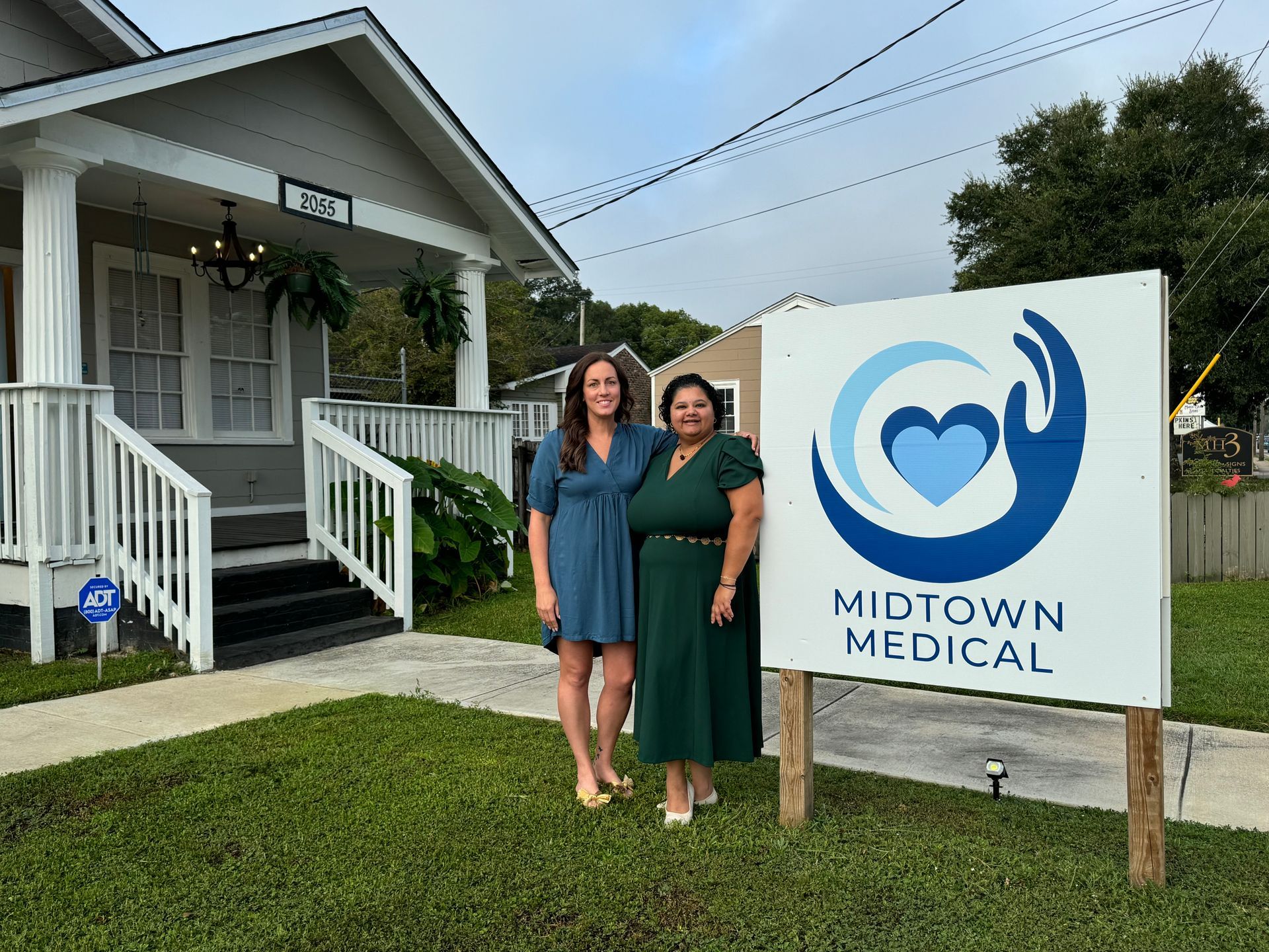 Two women are standing in front of a midtown medical sign.