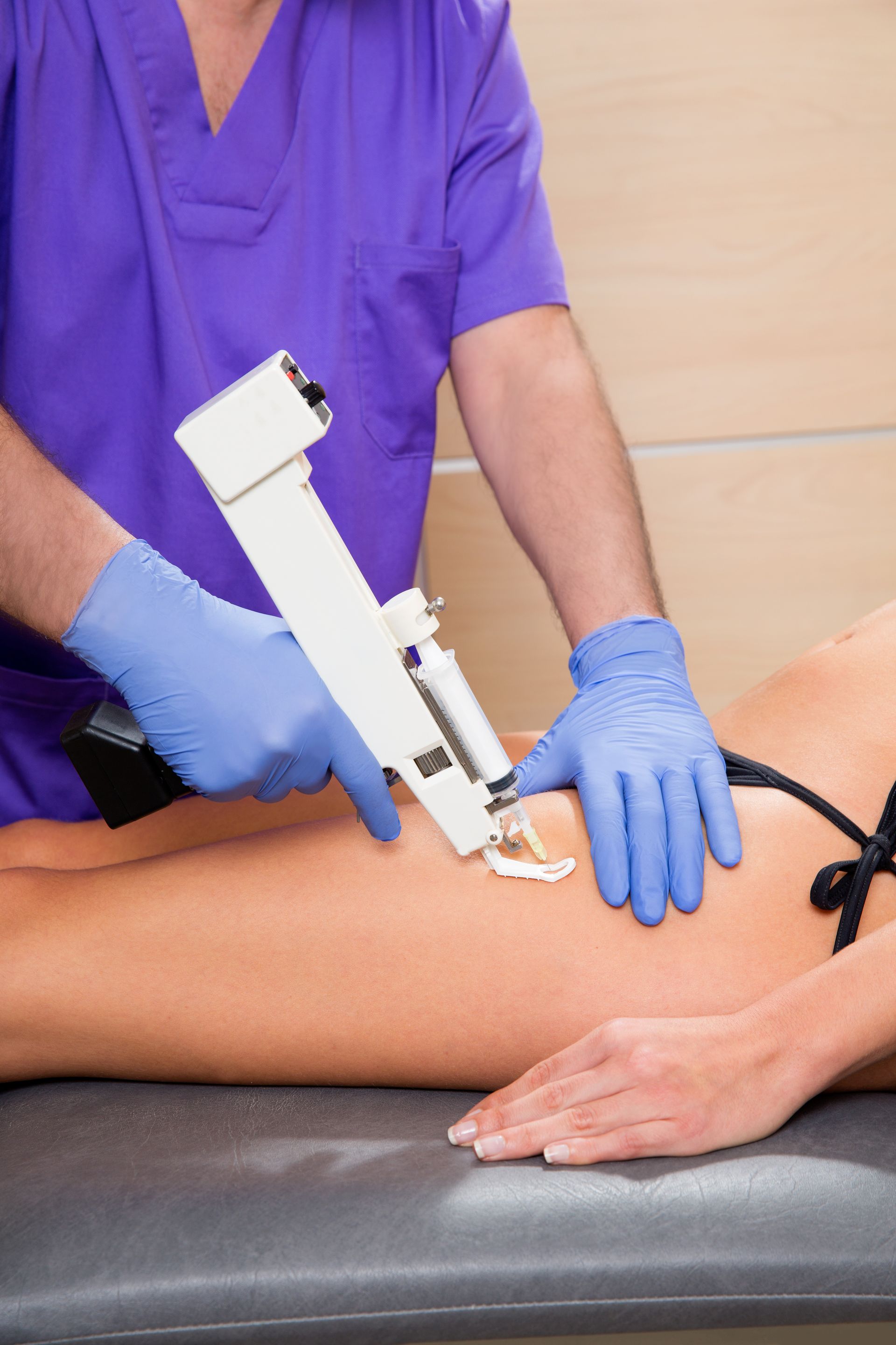 A woman in a bikini is getting an injection in her leg.