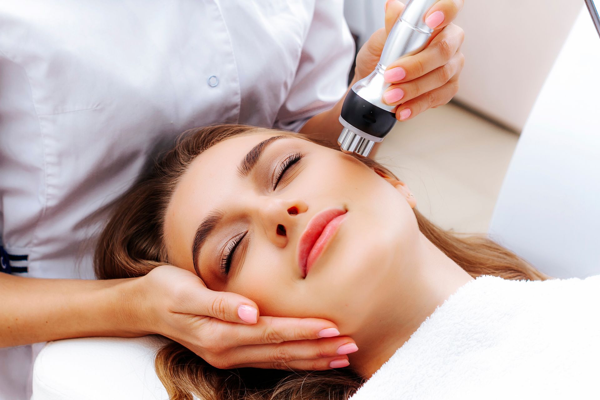 A woman is getting a facial treatment at a beauty salon.