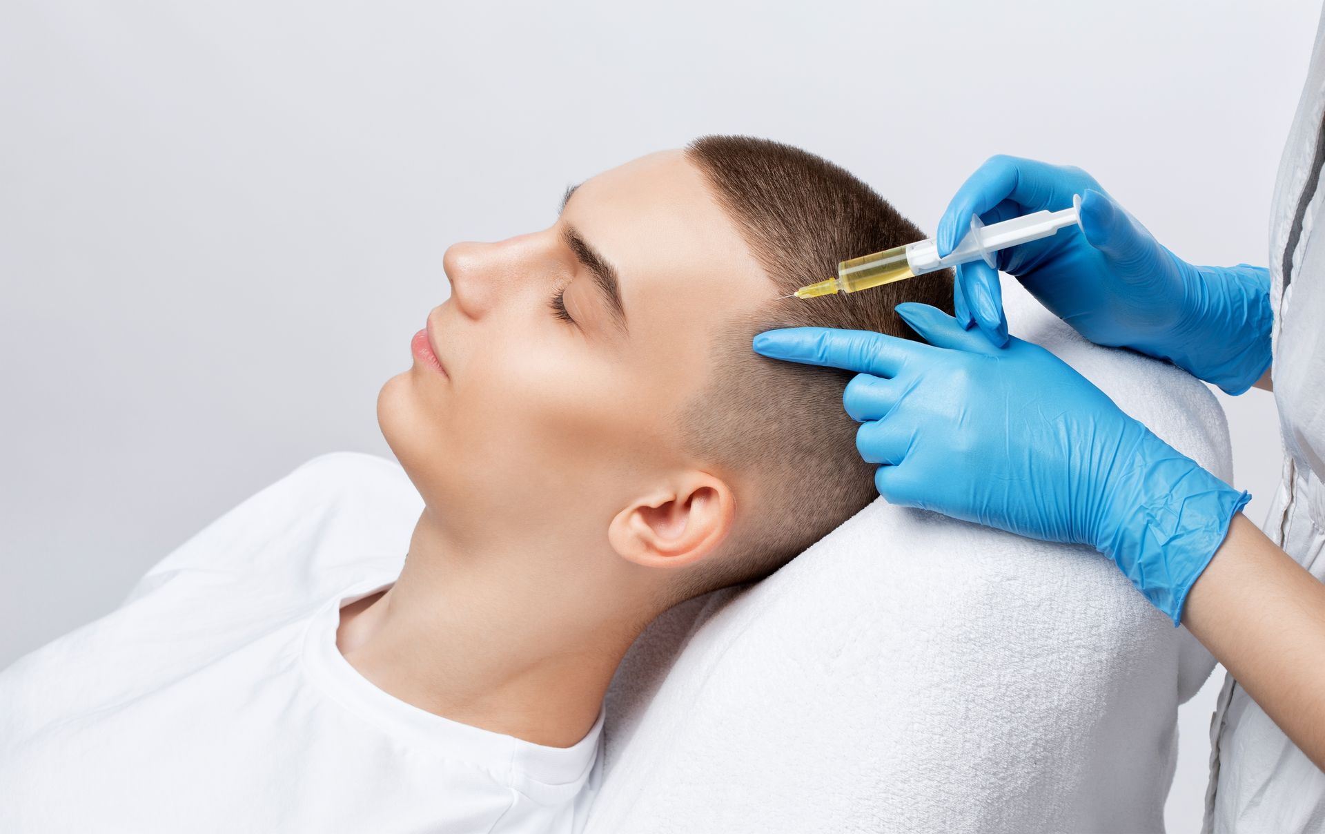 A man is getting an injection in his head in a beauty salon.