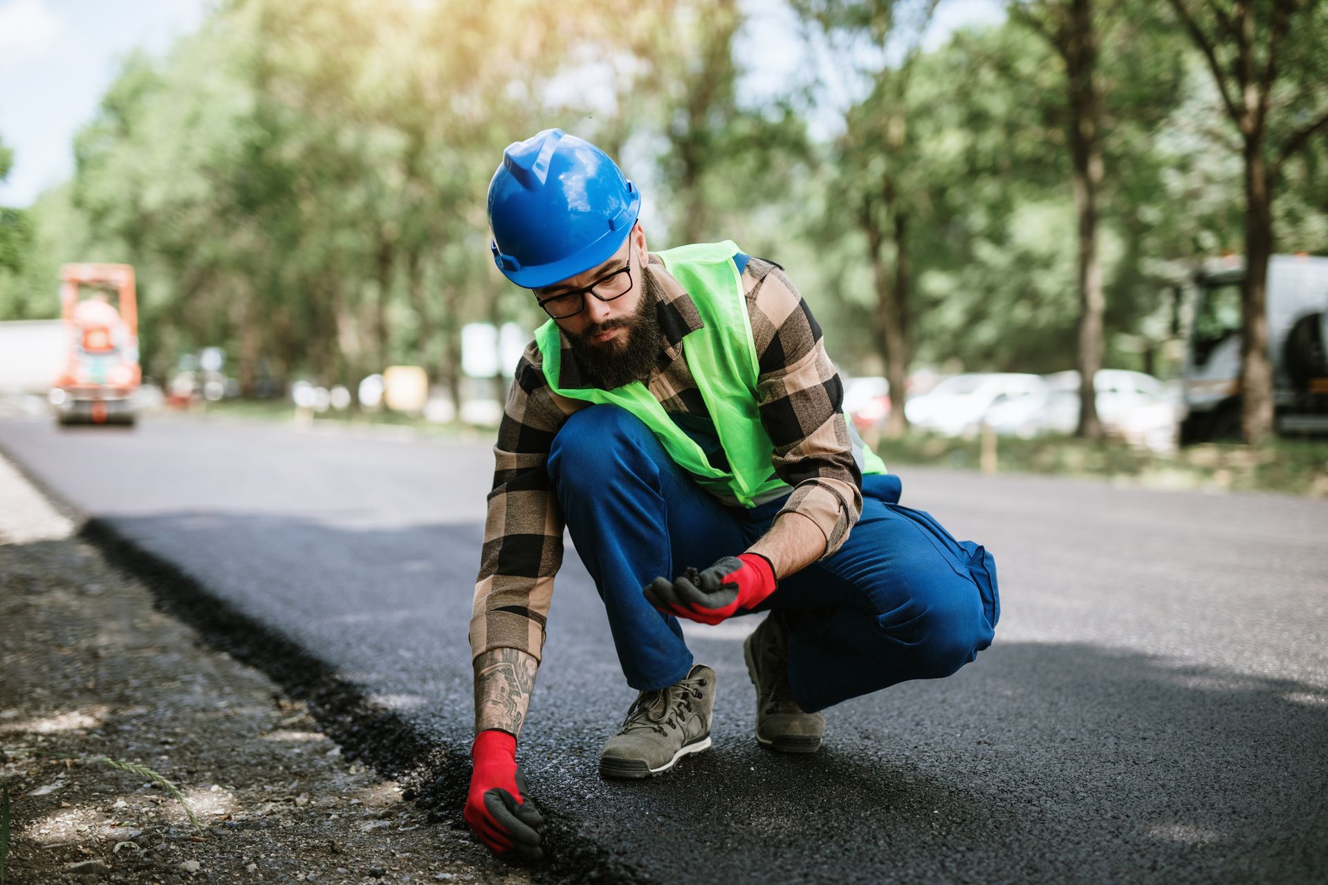 Pavement installation by a bearded construction worker on a sunny day.