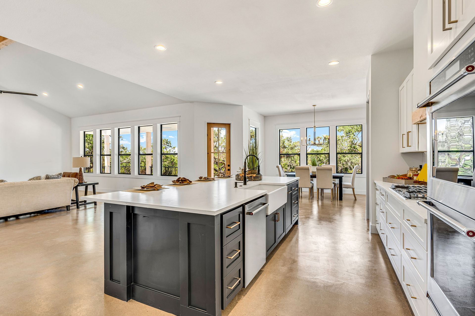 Modern kitchen with large island, stainless steel appliances, and dining area.