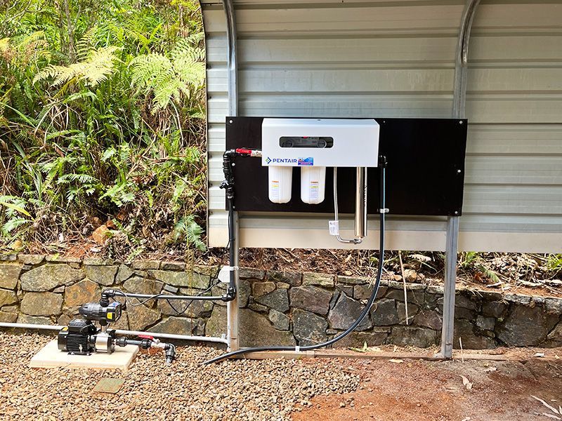 A Water Filter is Attached to the Side of a Building — The Pump Doctor In Kuluin, QLD