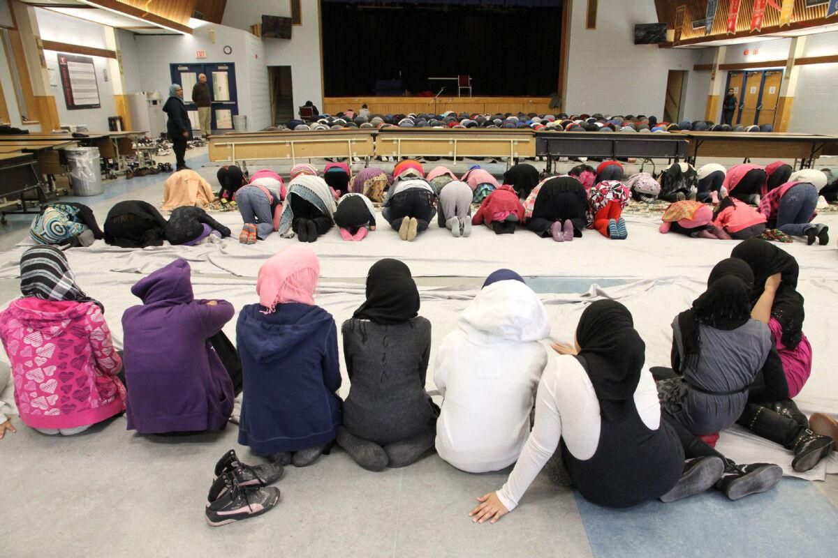 A group of people are sitting on the floor in front of a stage