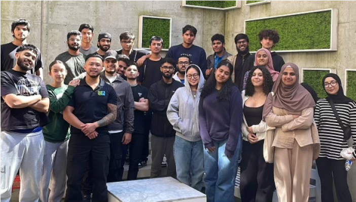 A group of people are posing for a picture in front of a wall.