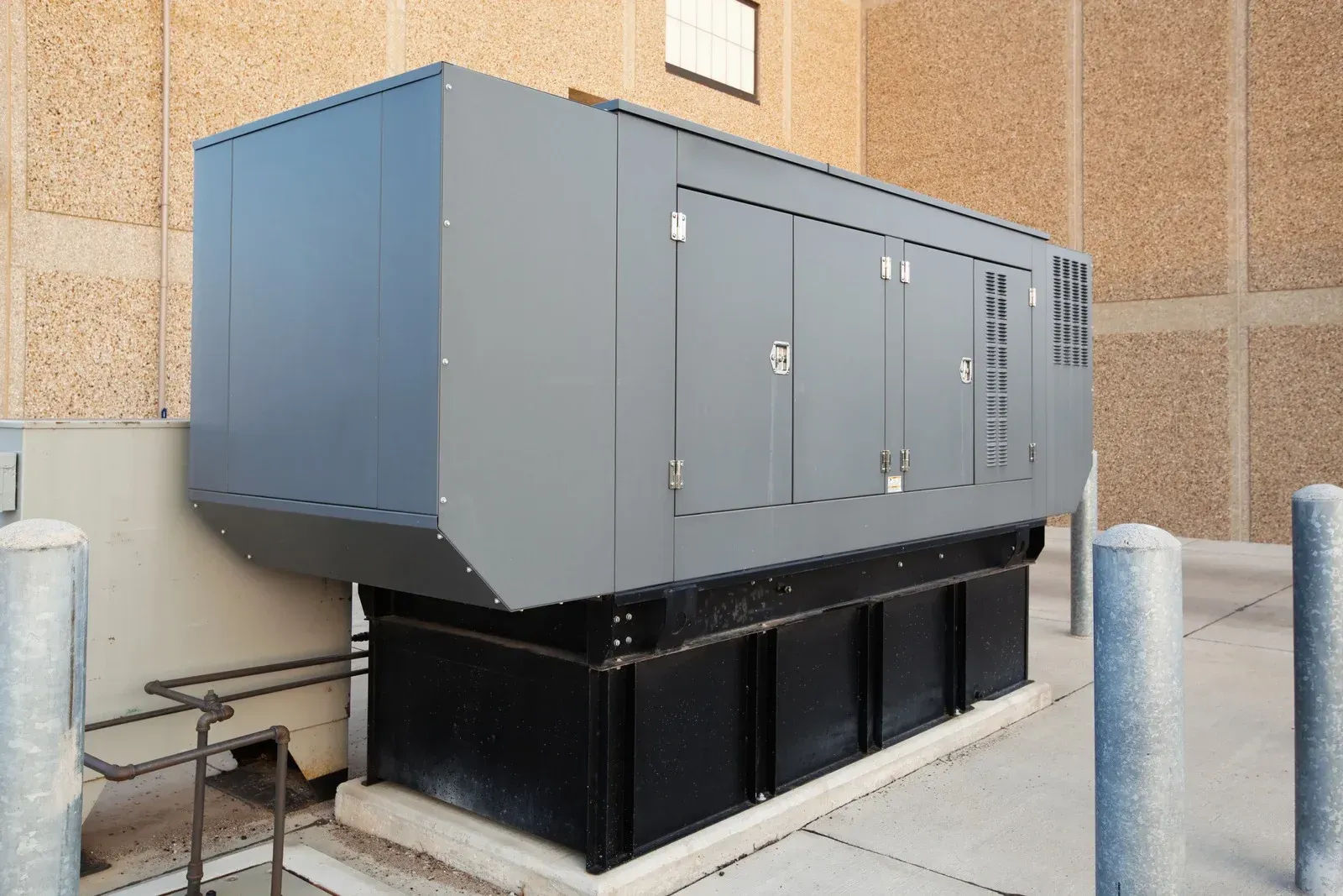 A large black box is sitting outside of a building.