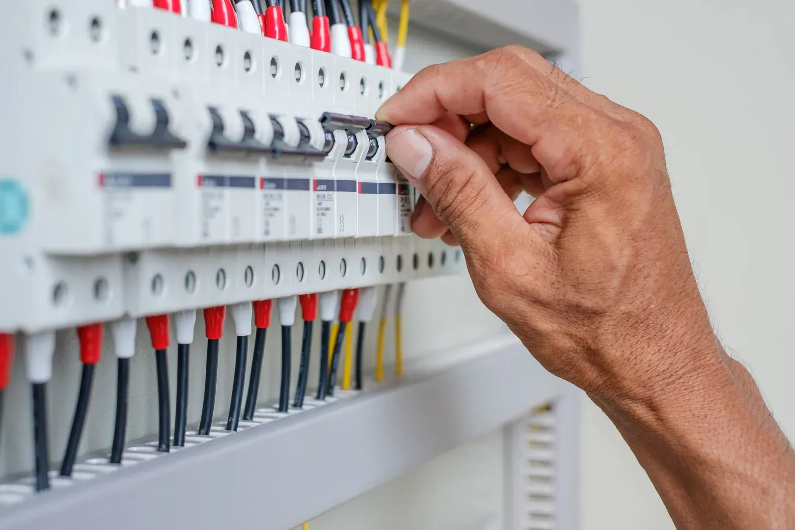 A close up of a person 's hand working on an electrical box.