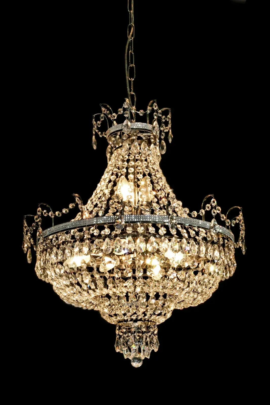 A chandelier is hanging from the ceiling with a black background