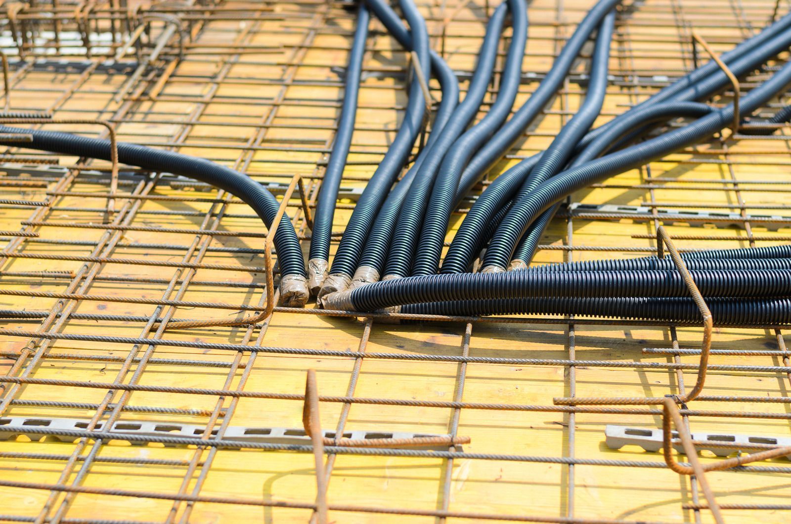 A bunch of wires are laying on the ground on a construction site.