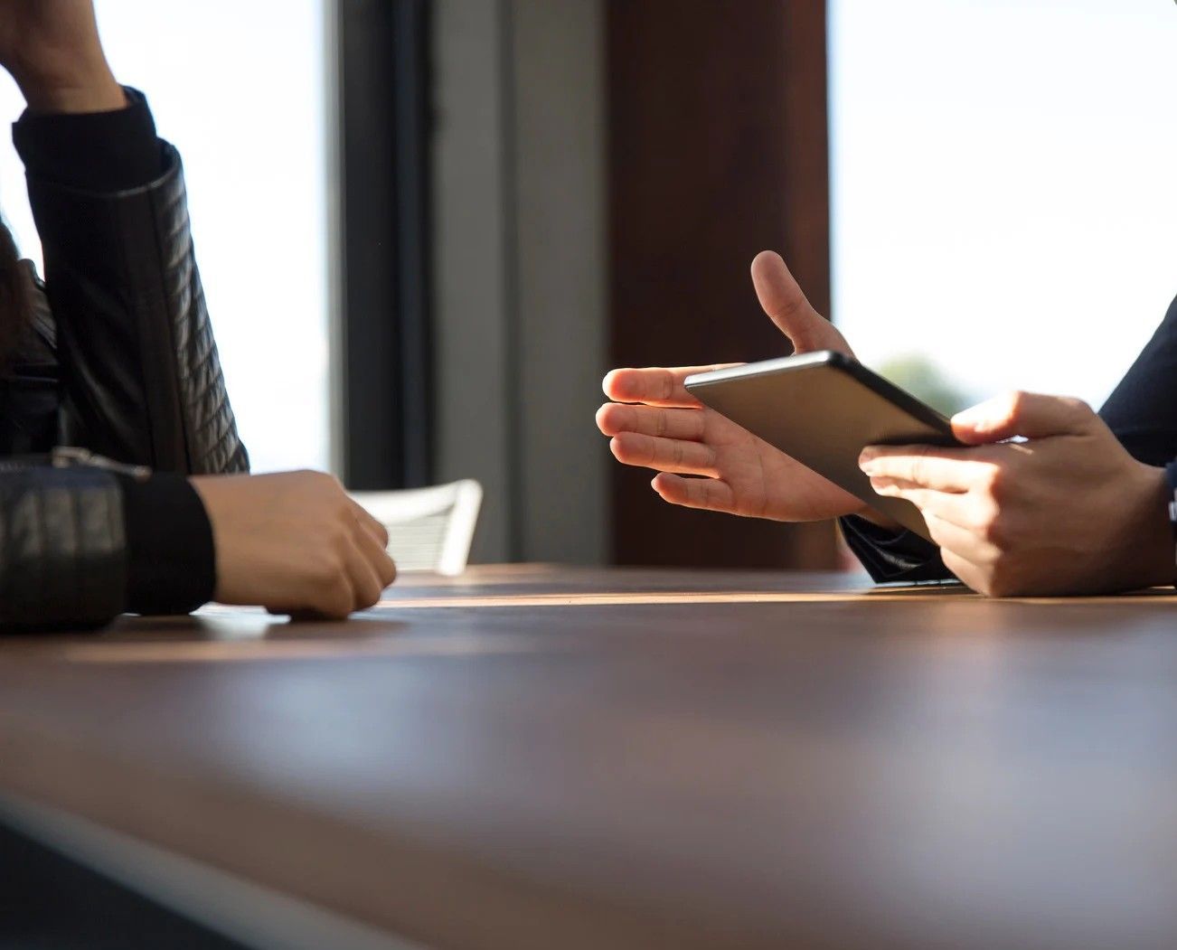 Two people are sitting at a table talking to each other