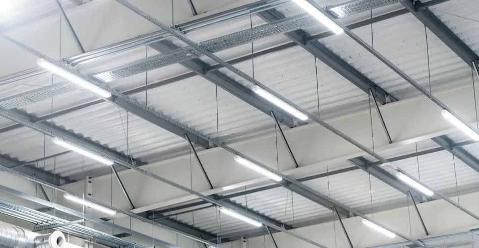 The ceiling of a building with lots of lights hanging from it.