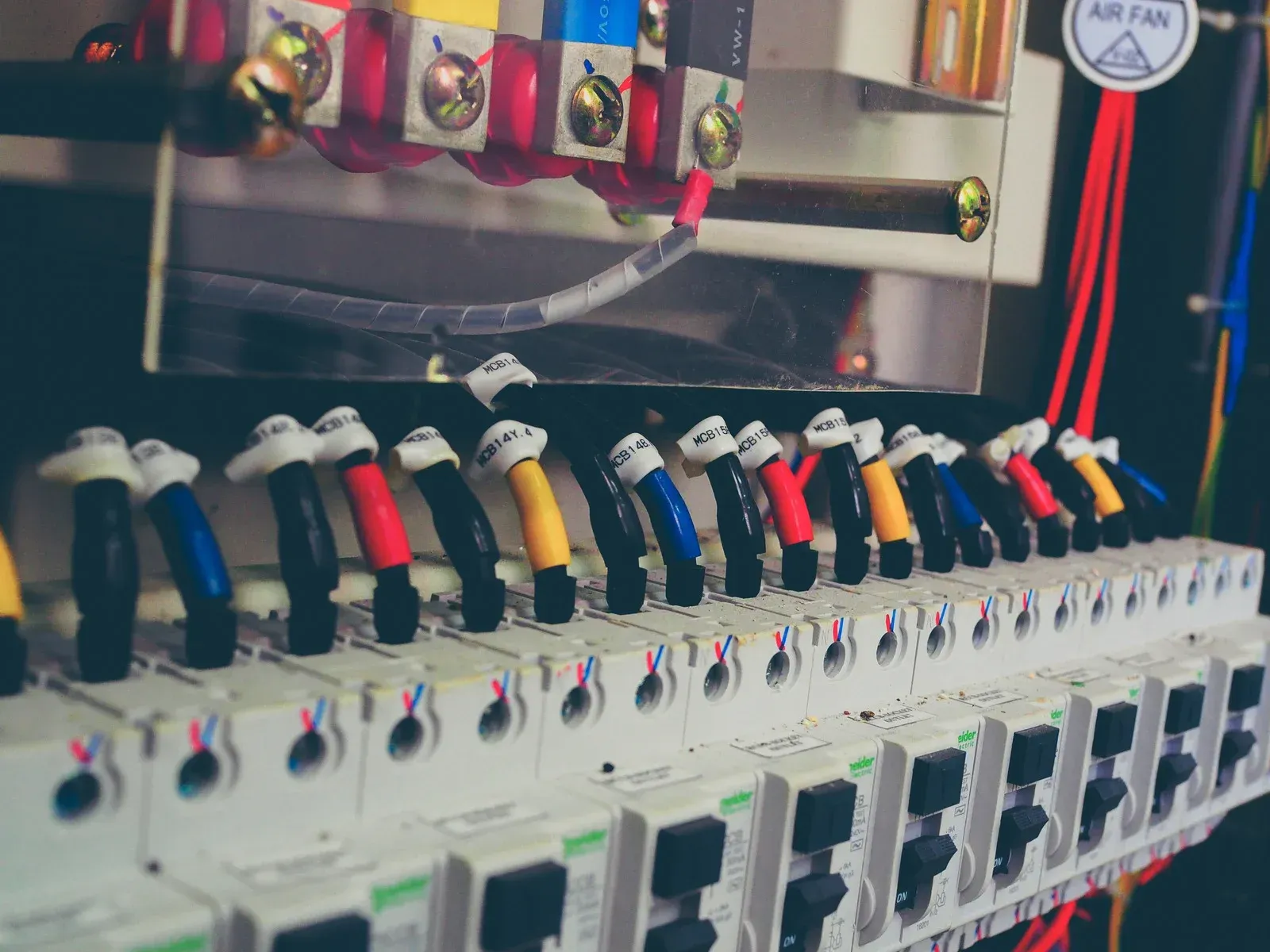 A close up of a row of electrical switches and wires.