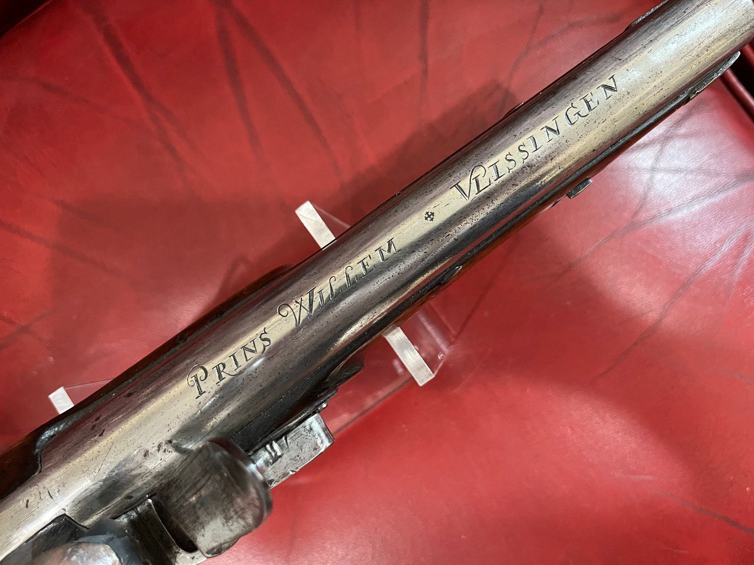 Close-up of a metal barrel with inscribed text: "Prins Willem" and "Vlissingen," likely part of an antique firearm.