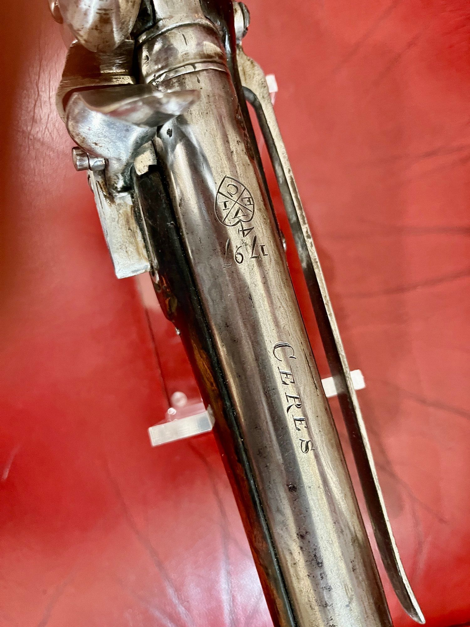 A close up of a silver object on a red surface.