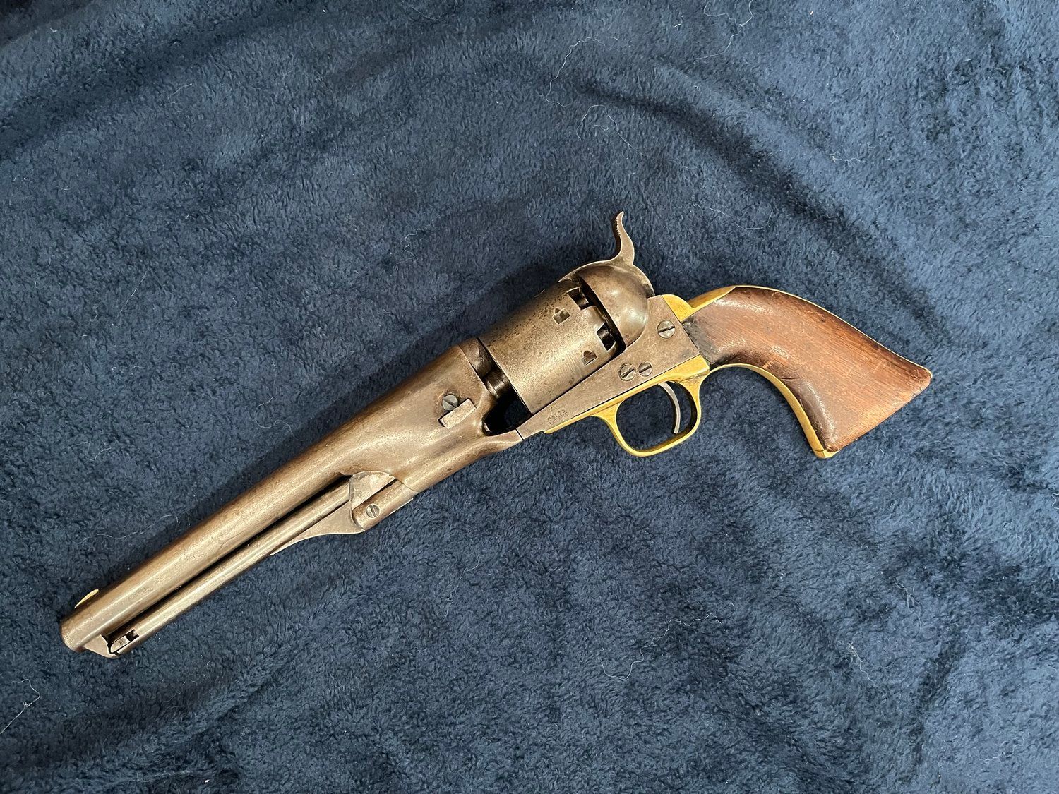 An old revolver is sitting on top of a blue blanket.