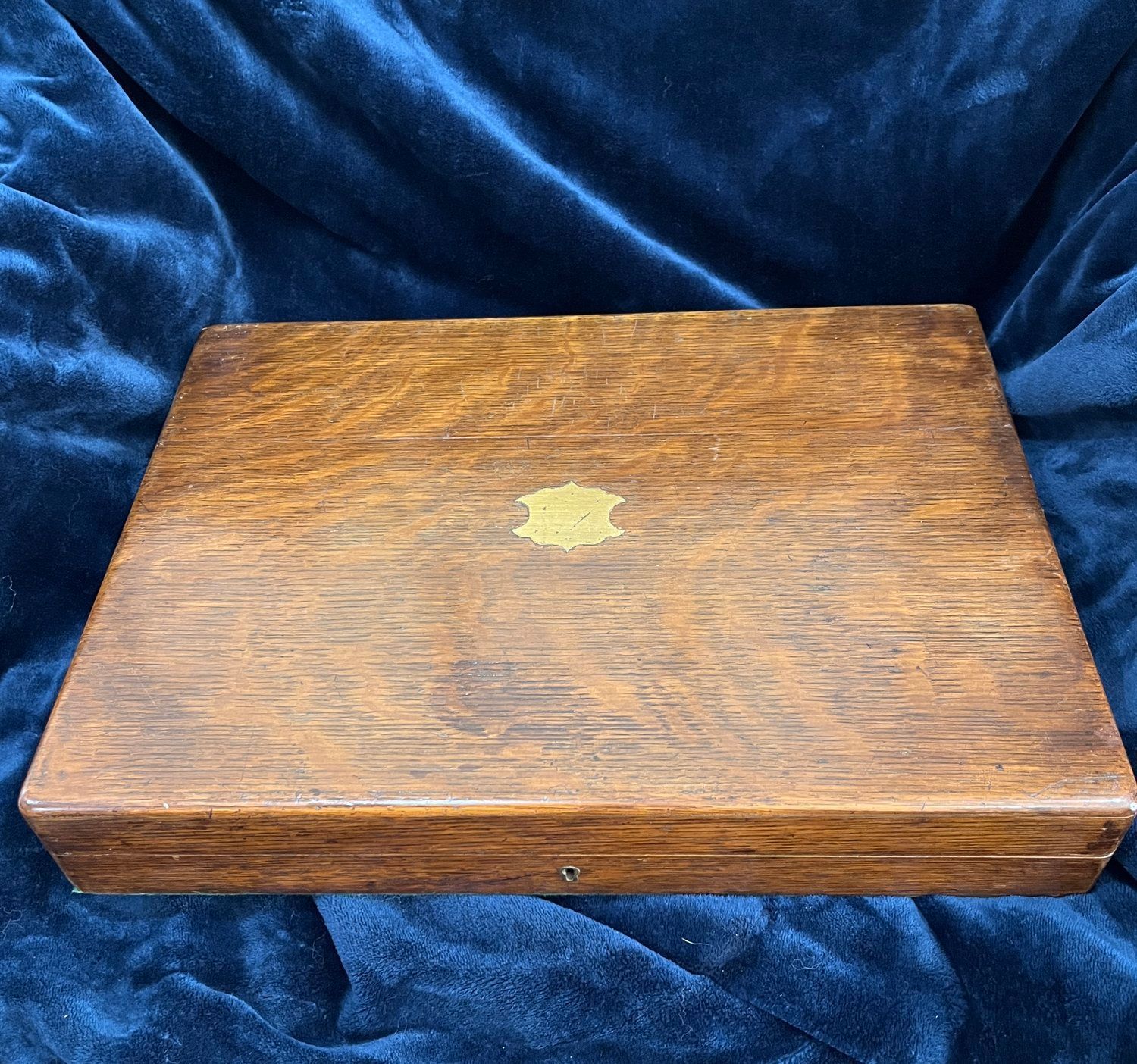 Open wooden case holding two antique pistols, a powder flask, a shot bag, and accessories.