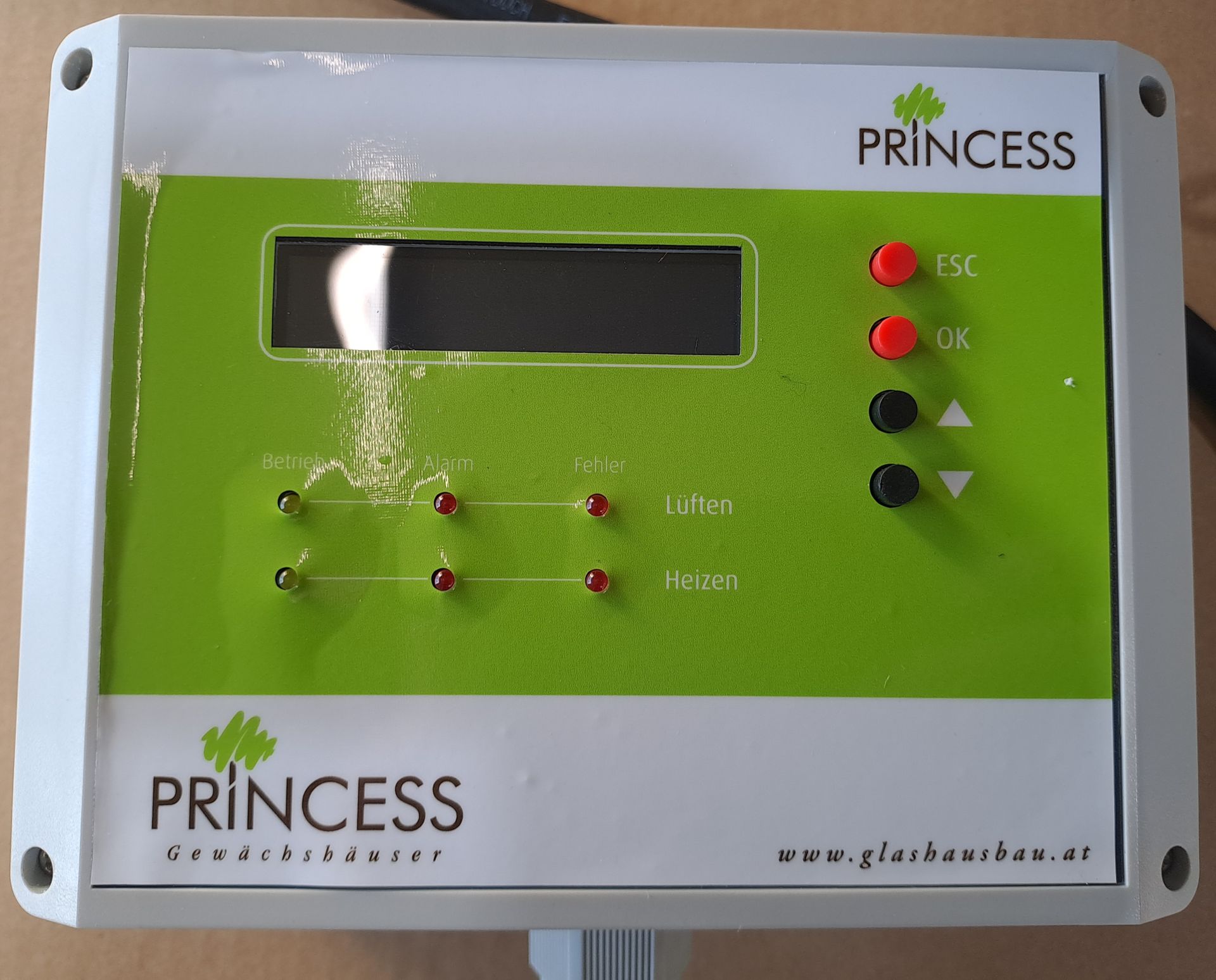 Weißer und grüner Princess-Controller mit Knöpfen, Lichtern und einem Display.