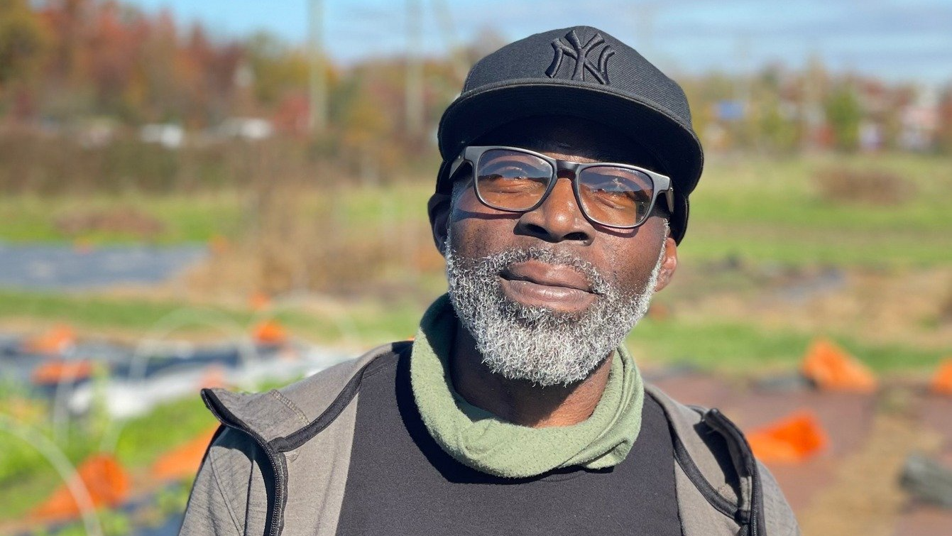 Marcus Roberson, a Black veteran farmer, standing in front of a farm field in Virginia