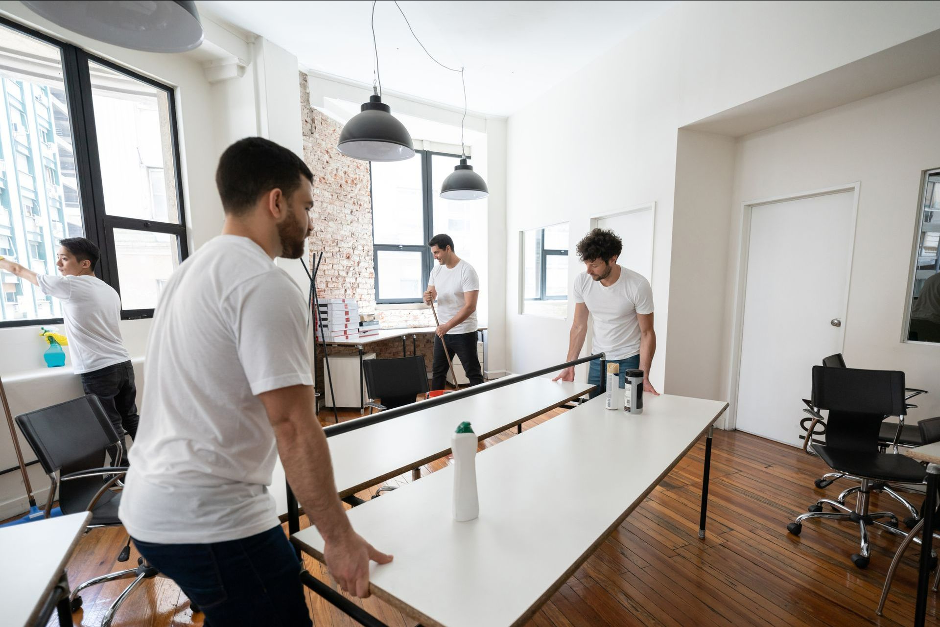 A Group Of Men Are Cleaning A Table In An Office — Aiken, NC — Aiken Junkmaster