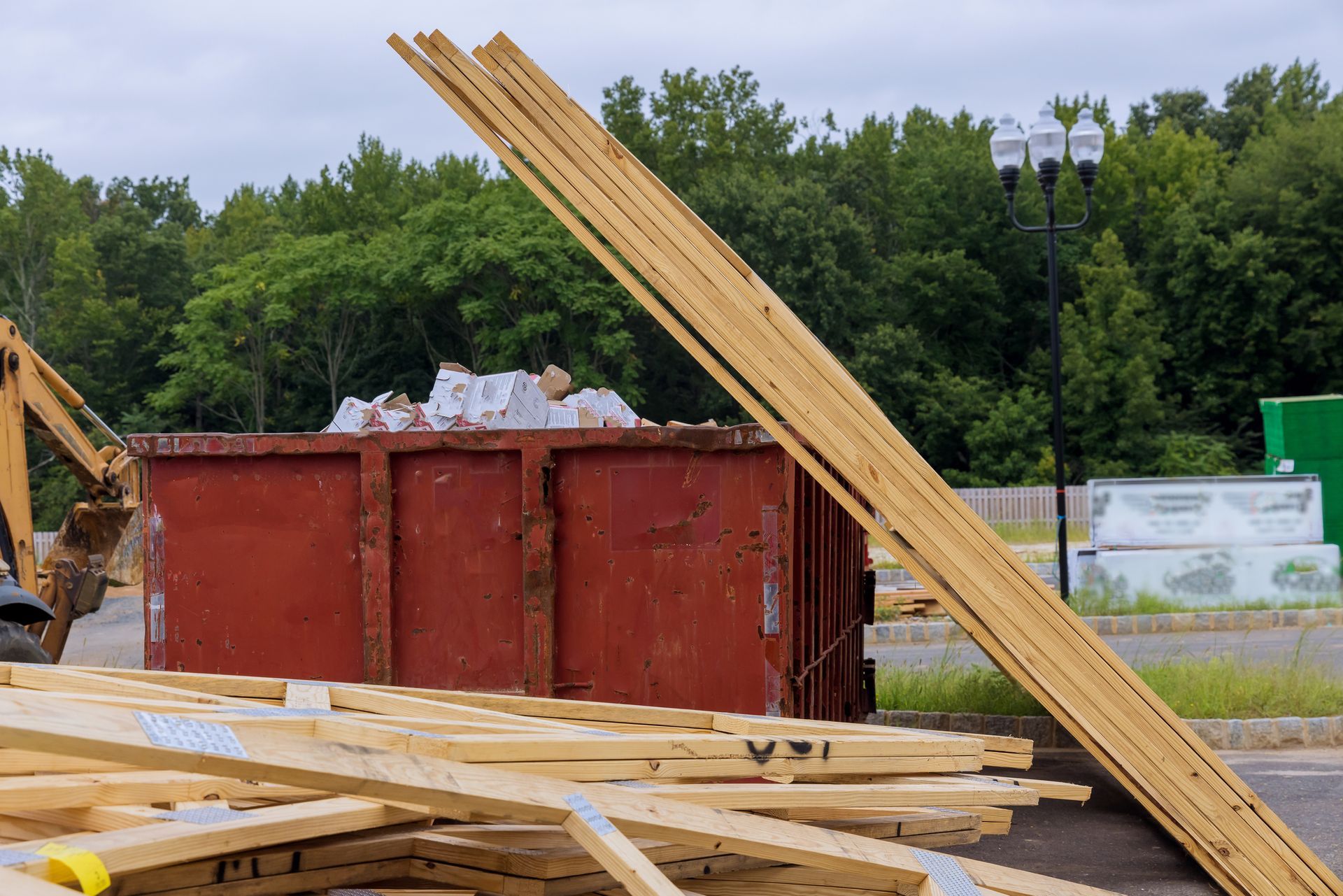 A Pile Of Wood Next To A Dumpster At A Construction Site — Aiken, NC — Aiken Junkmaster