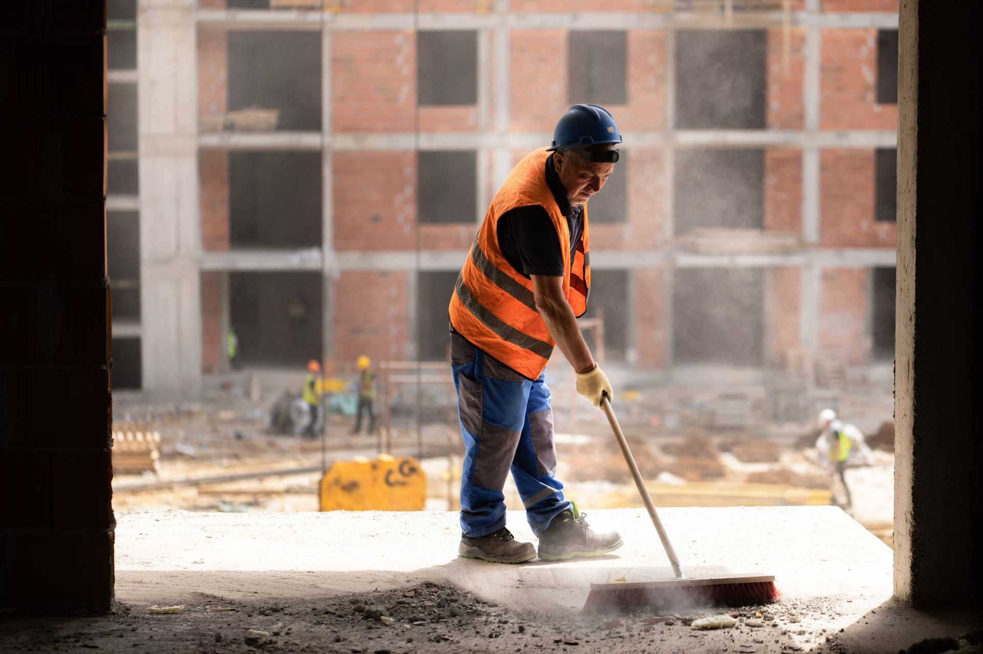 A Construction Worker Is Sweeping The Floor Of A Building Under Construction — Aiken, NC — Aiken Junkmaster