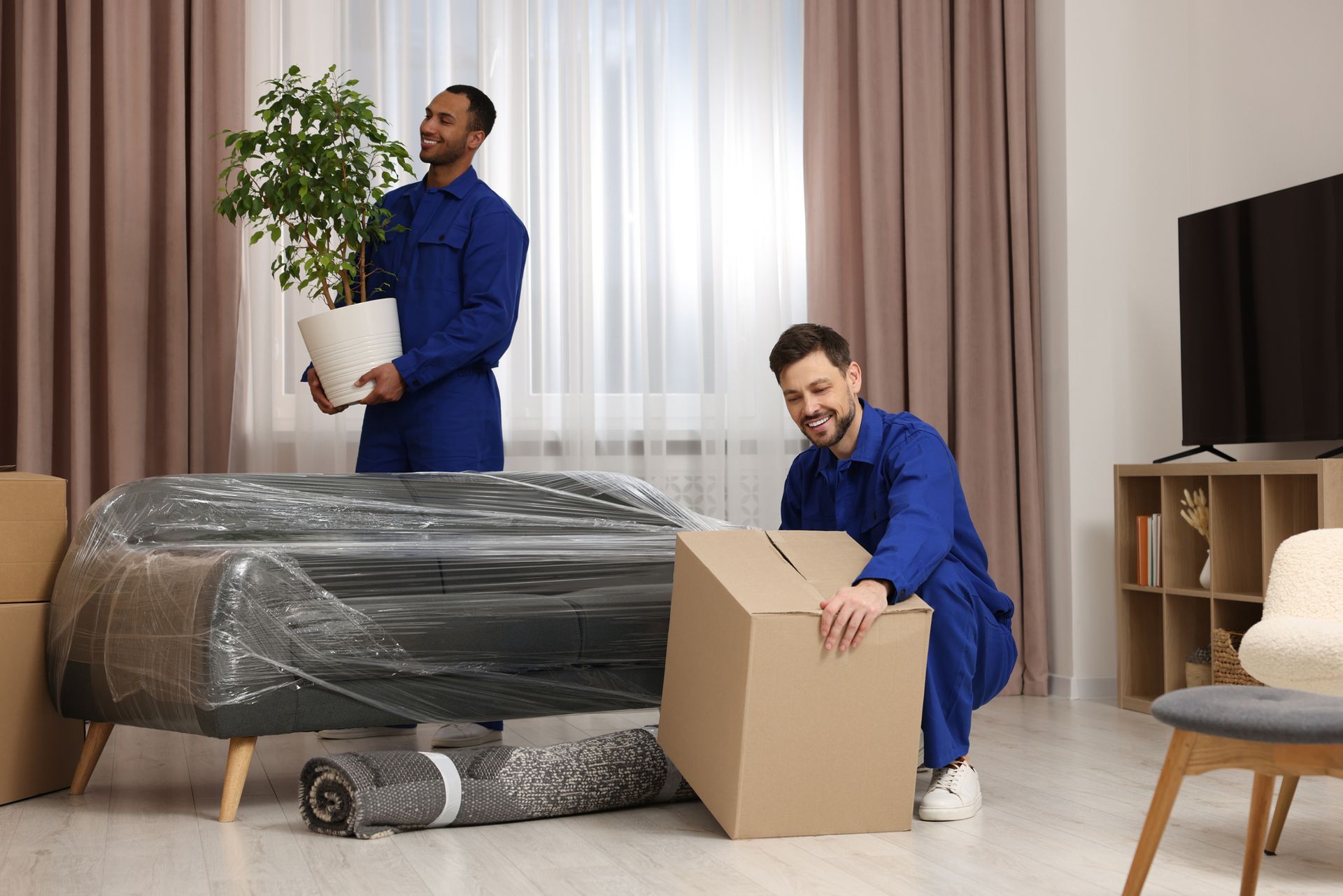 Two Men Are Moving A Couch In A Living Room — Aiken, NC — Aiken Junkmaster